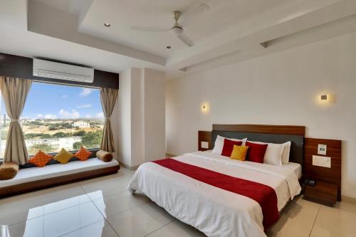a bedroom with a large bed and a window at Goverdhan Greens Resort in Dwarka