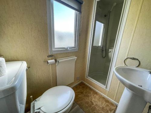 a bathroom with a toilet and a sink and a shower at Great Caravan At Valley Farm Holiday Park, Essex Ref 46583v in Great Clacton