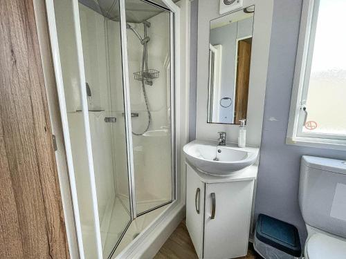 a bathroom with a shower and a sink at Gorgeous 6 Berth Caravan With Decking Area, Dovercourt Holiday Park Ref 44010af in Great Oakley