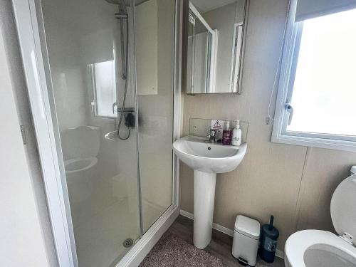 W łazience znajduje się prysznic, umywalka i toaleta. w obiekcie Gorgeous Caravan With Decking And Wi-fi At Carlton Meres In Suffolk Ref 60059fw w mieście Saxmundham