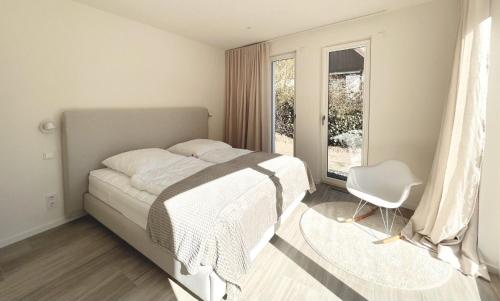een slaapkamer met een bed, een stoel en een raam bij Ferienwohnung Backbord in Kalifornien