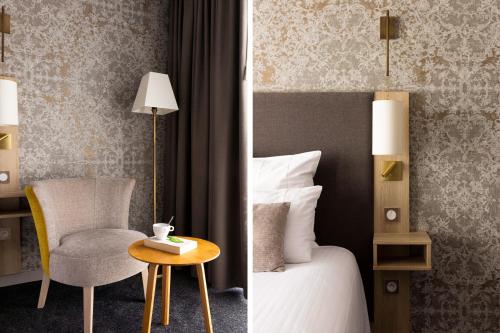 a bedroom with a bed and a chair and a table at James Boutique Hôtel Colmar centre in Colmar