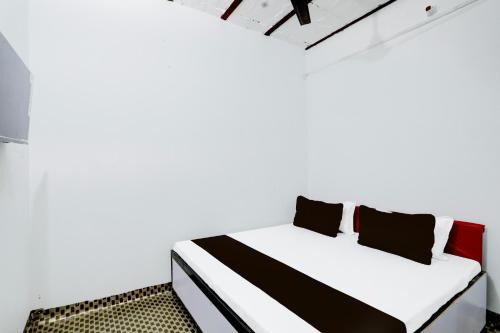 BulandshahrにあるSPOT ON Hotel T Townの白い部屋(黒と赤の枕が付くベッド付)