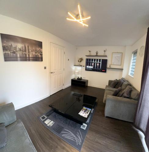 a living room with a couch and a table at Amersham Park Apartment in Manchester