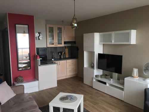 ein Wohnzimmer mit weißen Schränken und eine Küche in der Unterkunft Studio - MARINA 6 in Saint-Jean-de-Monts