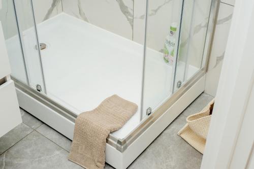 a stool in a bathroom with glass showers at Cozy Apartment - 4th Floor in Chişinău