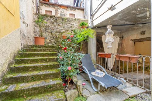 a stairway with a chair and flowers in a building at Antro Di Circe - Orta Centro in Orta San Giulio