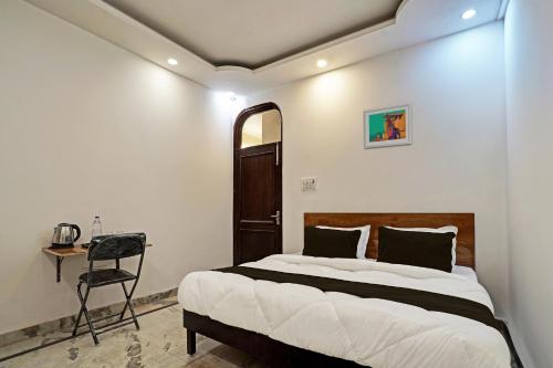 a bedroom with a bed and a desk and a chair at OYO Kiiza Stay House in New Delhi