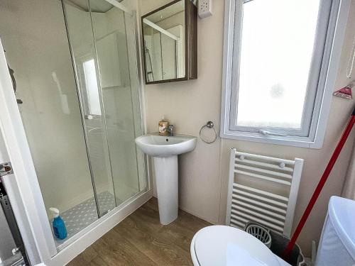 a bathroom with a sink and a shower at Gorgeous 6 Berth Caravan With Large Decking Area, Essex Ref 44009f in Great Oakley