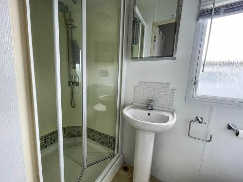 a bathroom with a glass shower and a sink at Great 8 Berth Caravan With Wifi At Dovercourt Holiday Park In Essex Ref 44003c in Great Oakley