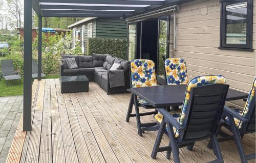 Un patio con una mesa y sillas y un sofá. en Amazing Stacaravan In Zeeland, en Zelanda