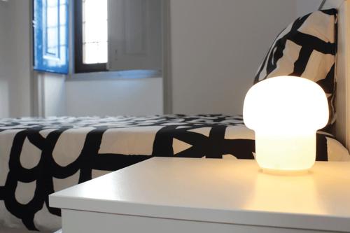 a lamp sitting on a table next to a bed at A CASA DA VILA in Almodôvar