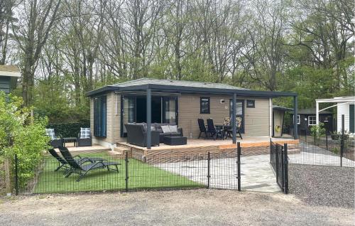 una casa pequeña con terraza y sillas en un patio en Amazing Stacaravan In Zeeland, en Zelanda
