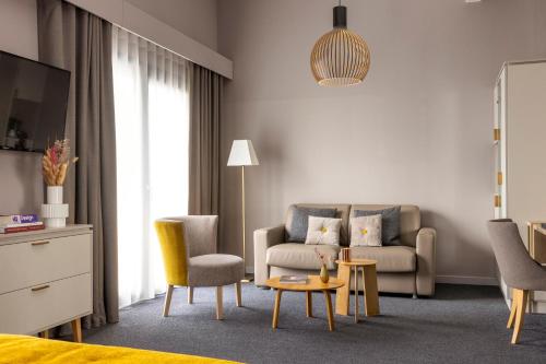 a living room with a couch and a chair at James Boutique Hôtel Colmar centre in Colmar