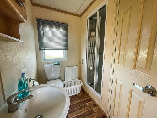 a bathroom with a sink and a toilet at Ref 40035nd - Superb Caravan With Decking Free Wifi At North Denes Holiday Park in Lowestoft