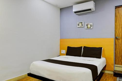 een slaapkamer met een wit bed en een blauwe muur bij OYO Hotel The Park View Rooms in Surat