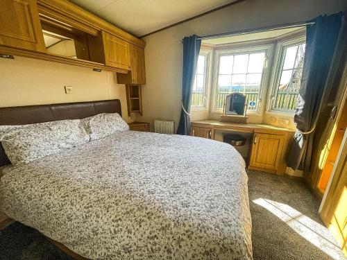 um quarto com uma cama, uma janela e uma televisão em Great 4 Berth Caravan For Hire In Suffolk At North Denes, Ref 40149nd em Lowestoft