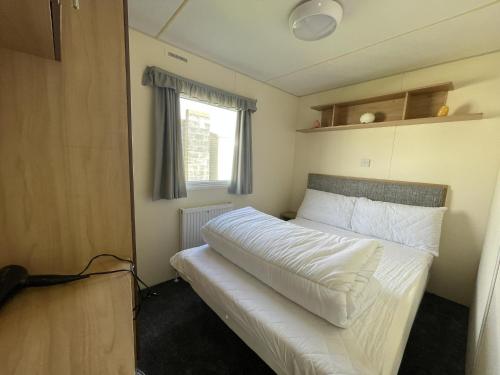 a bedroom with a bed in a small room at Great 8 Berth Caravan At Highfield Grange, Clacton-on-sea Ref 26214o in Clacton-on-Sea