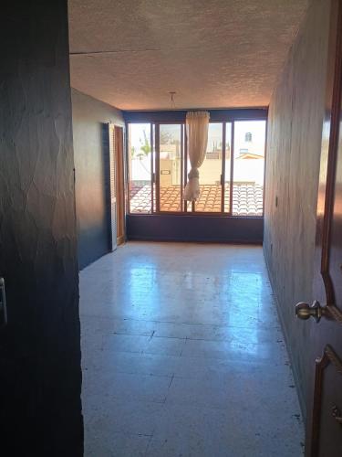 un corridoio vuoto con una porta e una finestra di La casa de Fonrouge a Guadalajara