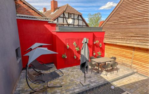 a patio with a table and chairs and a red wall at Ferienwohnung In Luxusvilla in Bahrdorf