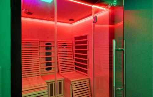 una ducha con luces rojas en una habitación en Ferienwohnung In Luxusvilla, 