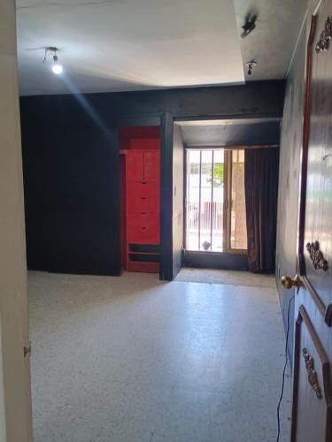 una stanza vuota con una porta rossa e una finestra di La casa de Fonrouge a Guadalajara