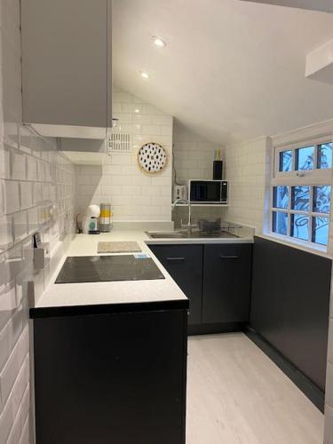 a kitchen with black cabinets and a counter top at SNUGGLES in Weymouth