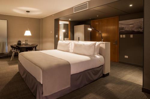 a hotel room with a large bed and a large mirror at Solace Hotel Santiago in Santiago
