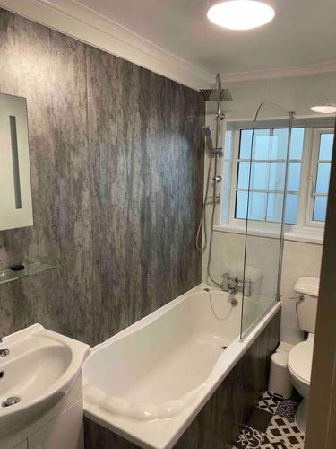a bathroom with a tub and a sink and a toilet at SNUGGLES in Weymouth