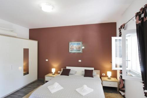 1 dormitorio con 1 cama con 2 almohadas blancas en Apartments Titonel, en Savudrija