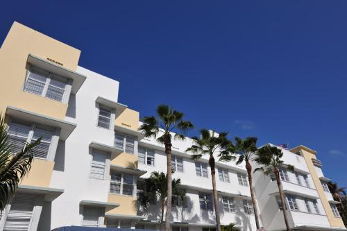 a building with palm trees in front of it at Avalon Hotel in Miami Beach