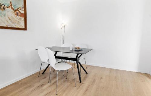 a dining room table with two white chairs and a painting at Nice Apartment In Gilleleje in Gilleleje