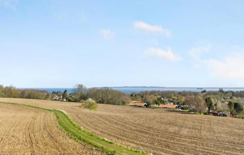an open field with a farm in the distance at Nice Apartment In Gilleleje in Gilleleje