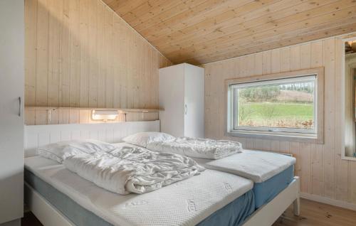 Cozy Home In Silkeborg With Wifi في سيلكبورج: سريرين في غرفة صغيرة مع نافذة
