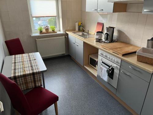 a kitchen with a counter and a table and chairs at Pension Kulturhaus Niederau in Niederau