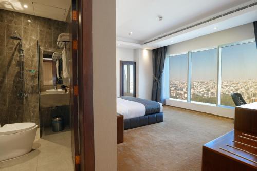 a hotel room with a bed and a bathroom at Celin Home Alsahafa - Riyadh City View in Riyadh