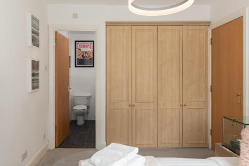 uma casa de banho com WC e um grande armário de madeira em Superb 1bed flat in Maida Vale em Londres