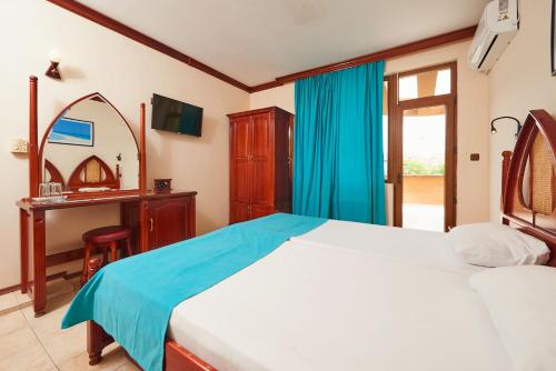 a bedroom with a bed and a vanity and a mirror at Hotel Manz 2 in Pomorie