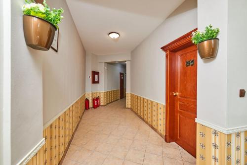 a hallway with two potted plants on the wall at Hotel Manz 2 in Pomorie