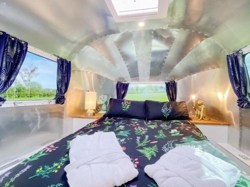 a bed in the middle of a room at Lanes End Farm Airstream in Hawthorn