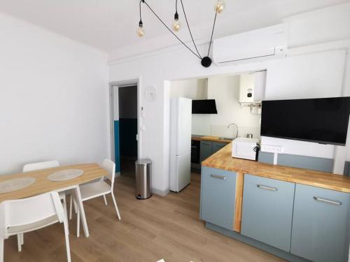 Il comprend une cuisine et une salle à manger avec une table et une télévision. dans l'établissement Sources bas chambre climatisation, à Avignon