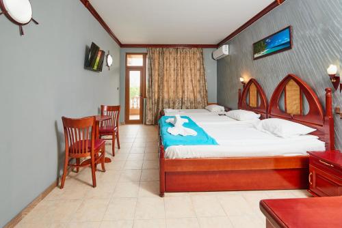 a bedroom with a bed with a towel on it at Hotel Manz 2 in Pomorie