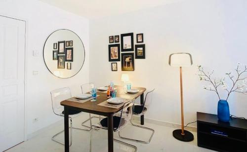 une salle à manger avec une table, des chaises et un miroir dans l'établissement Appartement Nice Palais de la Méditerranée, à Nice
