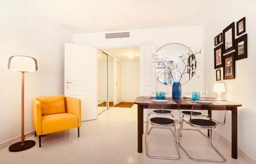 une salle à manger avec une table et une chaise jaune dans l'établissement Appartement Nice Palais de la Méditerranée, à Nice