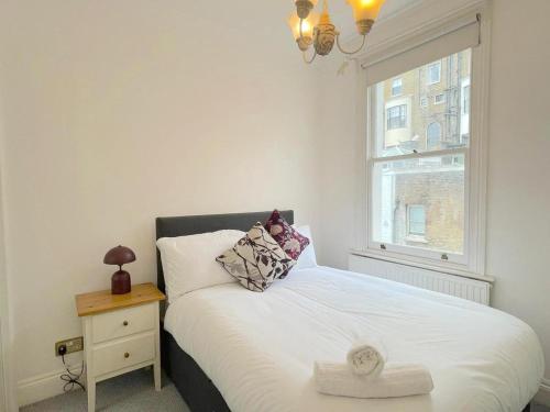1 dormitorio con 1 cama blanca y ventana en Luxury Apartment in Paddington, en Londres