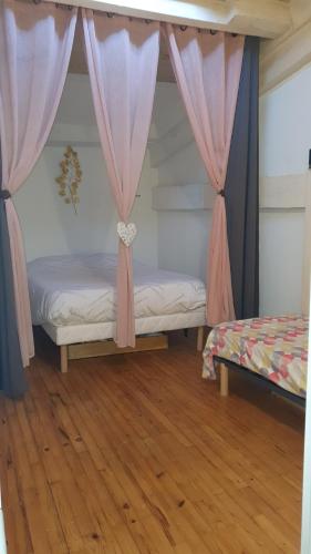 a bedroom with two beds with pink curtains at Victoire - Bordeaux in Bordeaux
