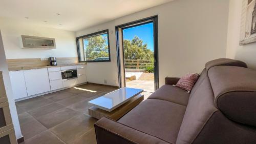 a living room with a couch and a table at Tres belle villa neuve vue mer avec piscine chauffee in Sainte-Lucie de Porto-Vecchio