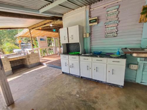 an outdoor kitchen with white cabinets and a stove at Shangrila-innibos Country Lodge in Hartbeespoort