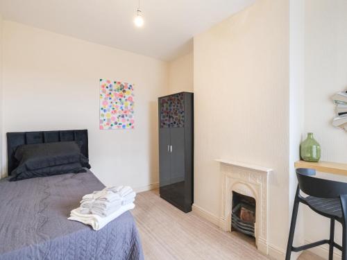 um quarto com uma cama e uma lareira em Lovely large 2-Bed House with 2 Reception Rooms em Atherstone