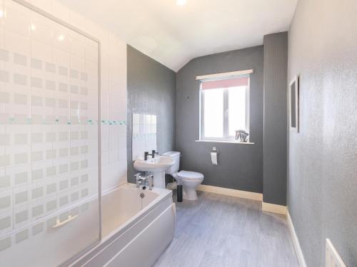 een badkamer met een bad, een toilet en een wastafel bij Lovely large 2-Bed House with 2 Reception Rooms in Atherstone